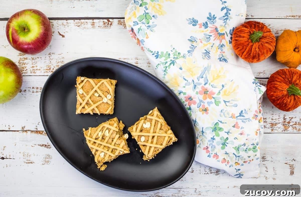 33 Irresistible Fall Desserts That Defy Portion Control 18 Two brown butter apple blondies were placed on a white surface.