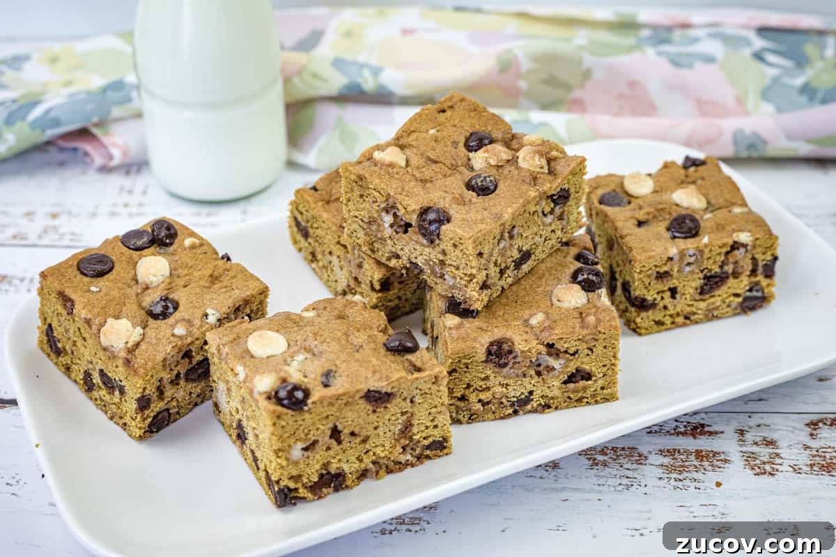 33 Irresistible Fall Desserts That Defy Portion Control 32 A white rectangular plate with pieces of pumpkin blondies.