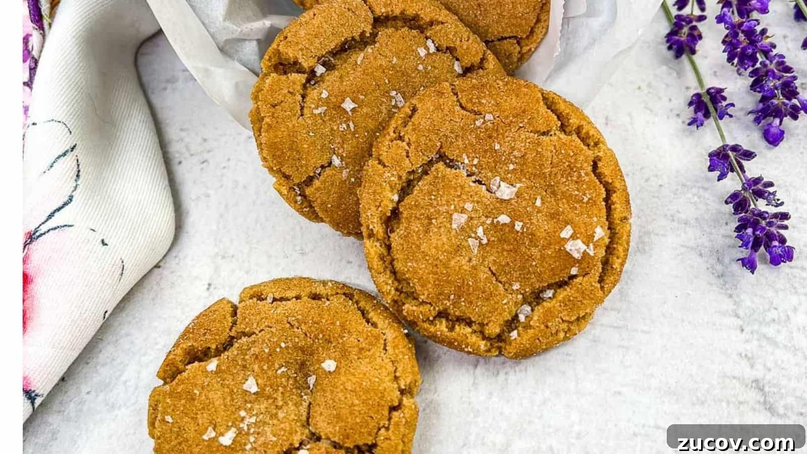 33 Irresistible Fall Desserts That Defy Portion Control 33 Three brown butter snickerdoodle cookies arranged on a white surface, sprinkled with sea salt flakes, with a white cloth and purple flowers on the side.