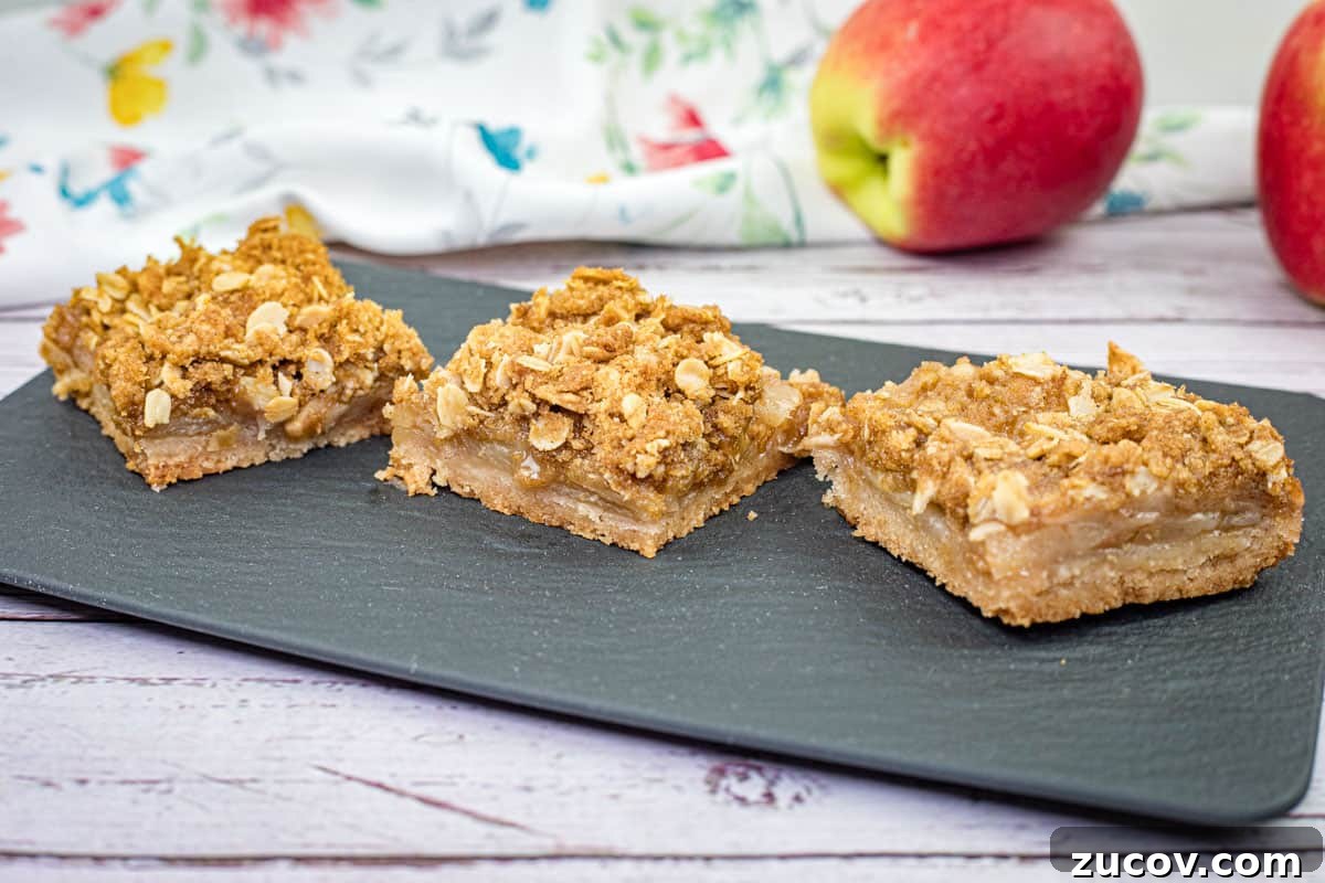 33 Irresistible Fall Desserts That Defy Portion Control 35 Three pieces of Dutch Apple Pie Squares on a black slate plate.