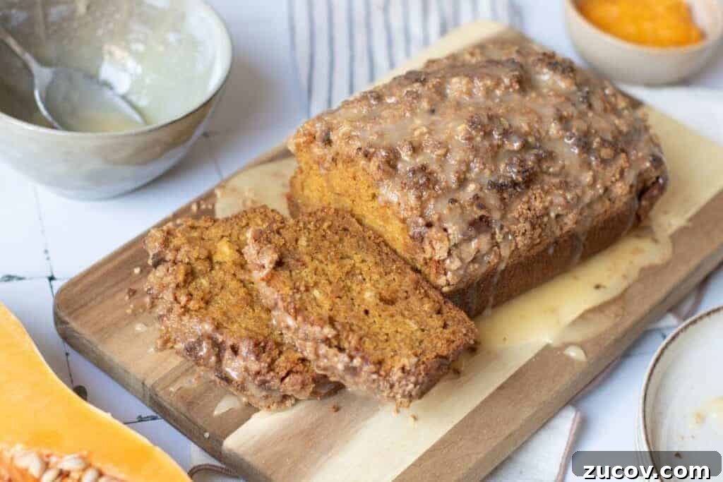 33 Irresistible Fall Desserts That Defy Portion Control 5 A loaf of glazed pumpkin bread with two slices cut sits on a wooden cutting board, surrounded by bowls containing glaze and orange puree.
