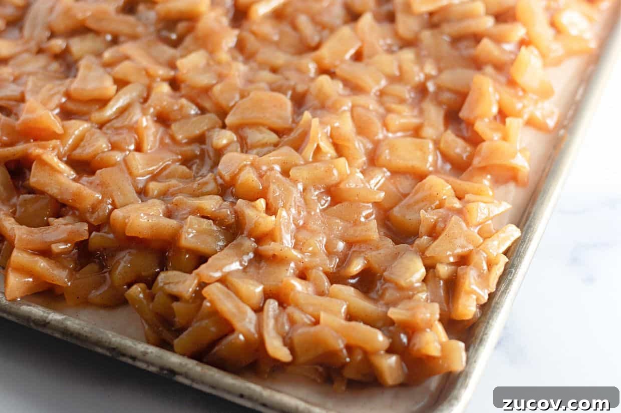 33 Irresistible Fall Desserts That Defy Portion Control 6 A baking tray filled with a layer of chopped apples coated in a cinnamon-sugar mixture.