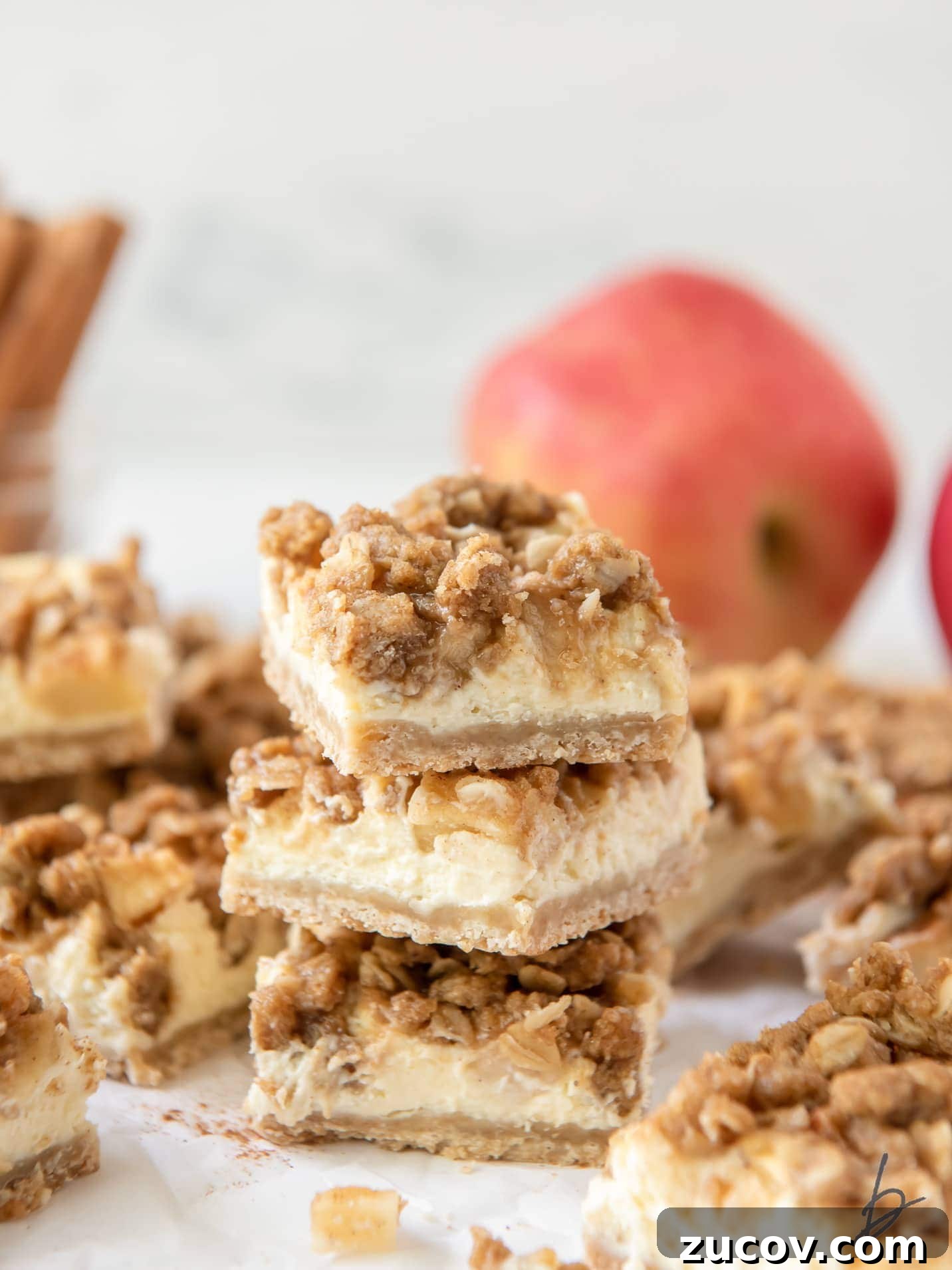 Apple Cheesecake Bars Recipe with Cinnamon Streusel 2 stack of three apple cheesecake bars showing layers of shortbread crust, cheesecake, apples and streusel