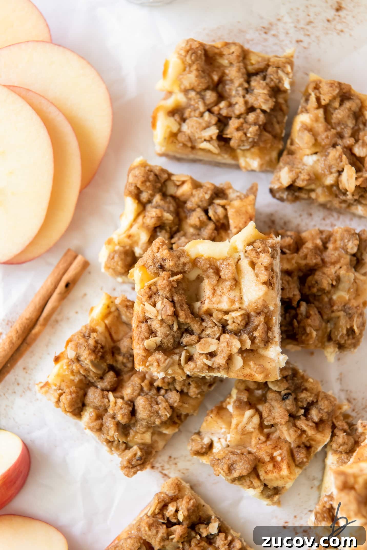 Apple Cheesecake Bars Recipe with Cinnamon Streusel 3 apple cheesecake bar on top of more apple cheesecake bars