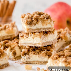Apple Cheesecake Bars Recipe with Cinnamon Streusel 7 stack of three apple cheesecake bars in front of more bars and apples