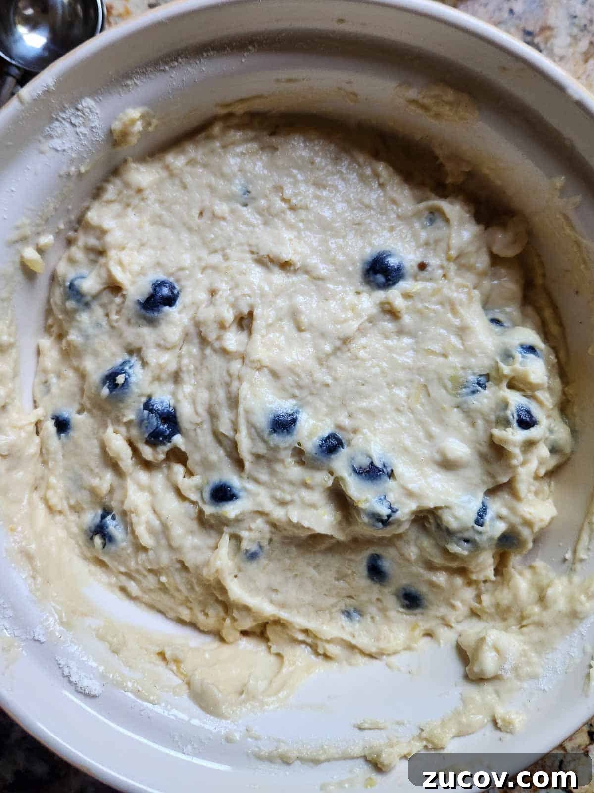 Bakery-Style Blueberry Lemon Muffins Recipe for Moist, Zesty Muffins 6 Blueberry muffin batter in a large bowl.