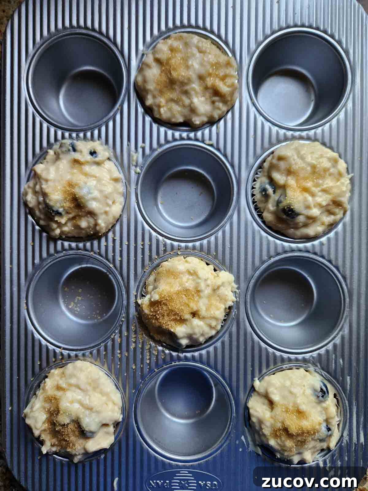 Bakery-Style Blueberry Lemon Muffins Recipe for Moist, Zesty Muffins 7 Muffin batter in a muffin tin filled every other well.