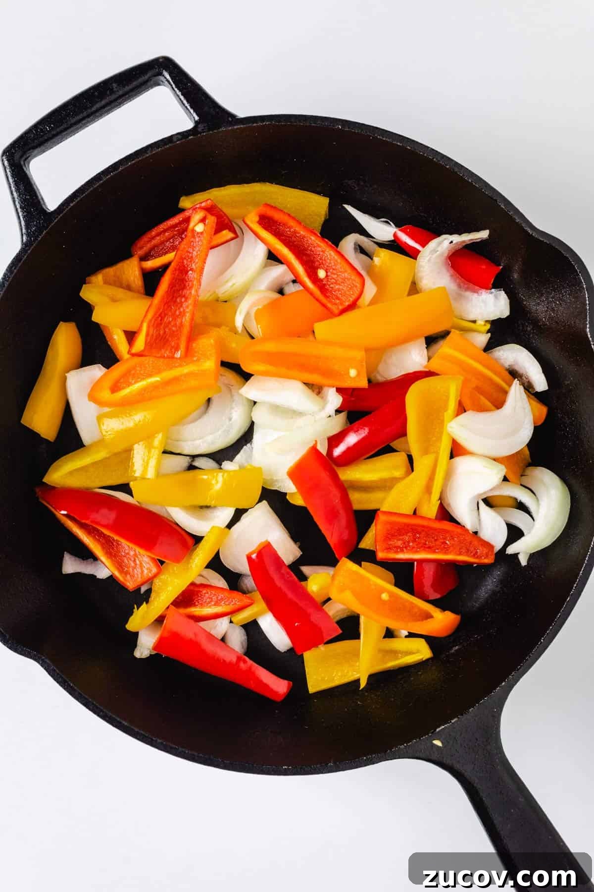 Creamy Polenta with Caramelized Onions and Sautéed Peppers 6 Sliced bell peppers and onions in a cast-iron skillet.