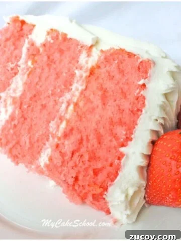 Slice of three layer strawberry cake from cake mix on a plate, next to two fresh strawberries.