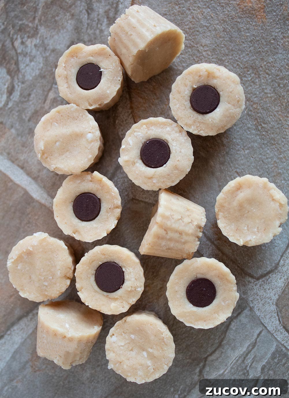 Keto Peanut Butter Chocolate Chip Cookie Recipe 9 keto peanut butter fat bombs on a tile with chocolate chips in the middle of some
