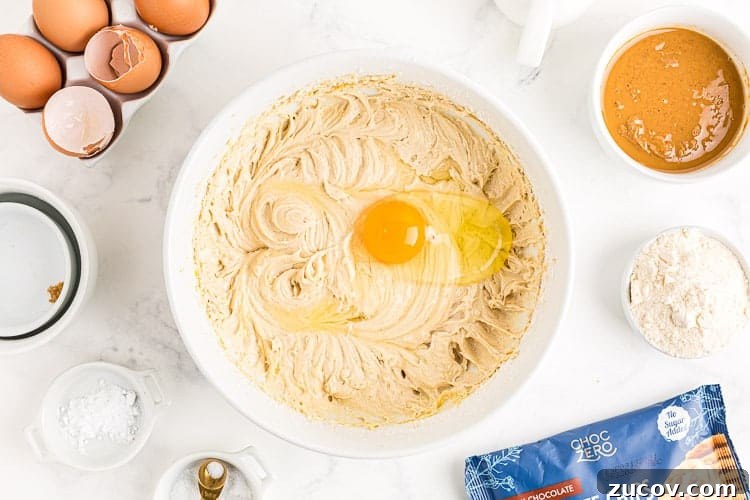 Keto Peanut Butter Chocolate Chip Cookie Recipe 3 overhead view of bowl with egg on top of cookie batter