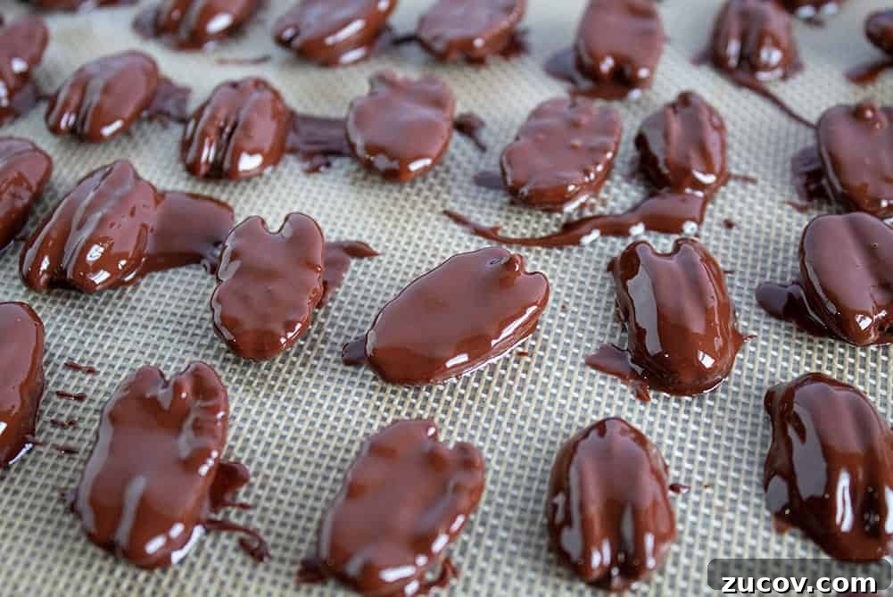 Keto Peanut Butter Chocolate Chip Cookie Recipe 16 closeup of chocolate covered pecans with several broken in half