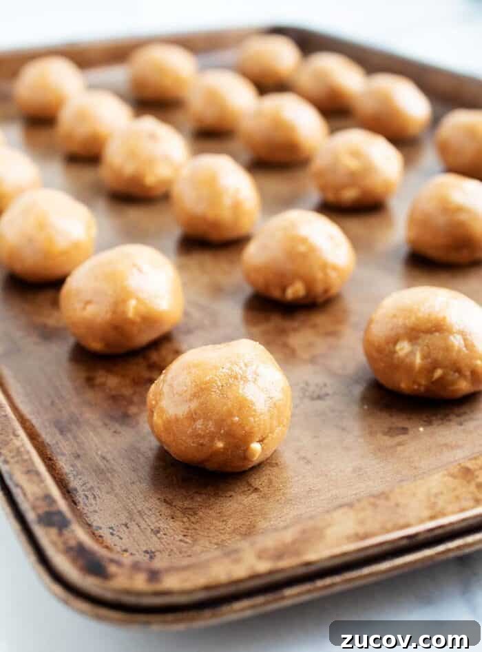 Keto Peanut Butter Chocolate Chip Cookie Recipe 7 3 ingredient peanut butter balls lined up on a baking tray