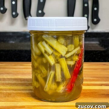 Crisp Quick Pickled Asparagus Recipe for Flavorful Snacks 2 Mason jar with white lid and pickled collard stems in the jar.