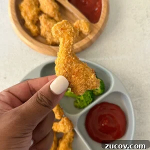 Dino nuggets served with broccoli and ketchup.