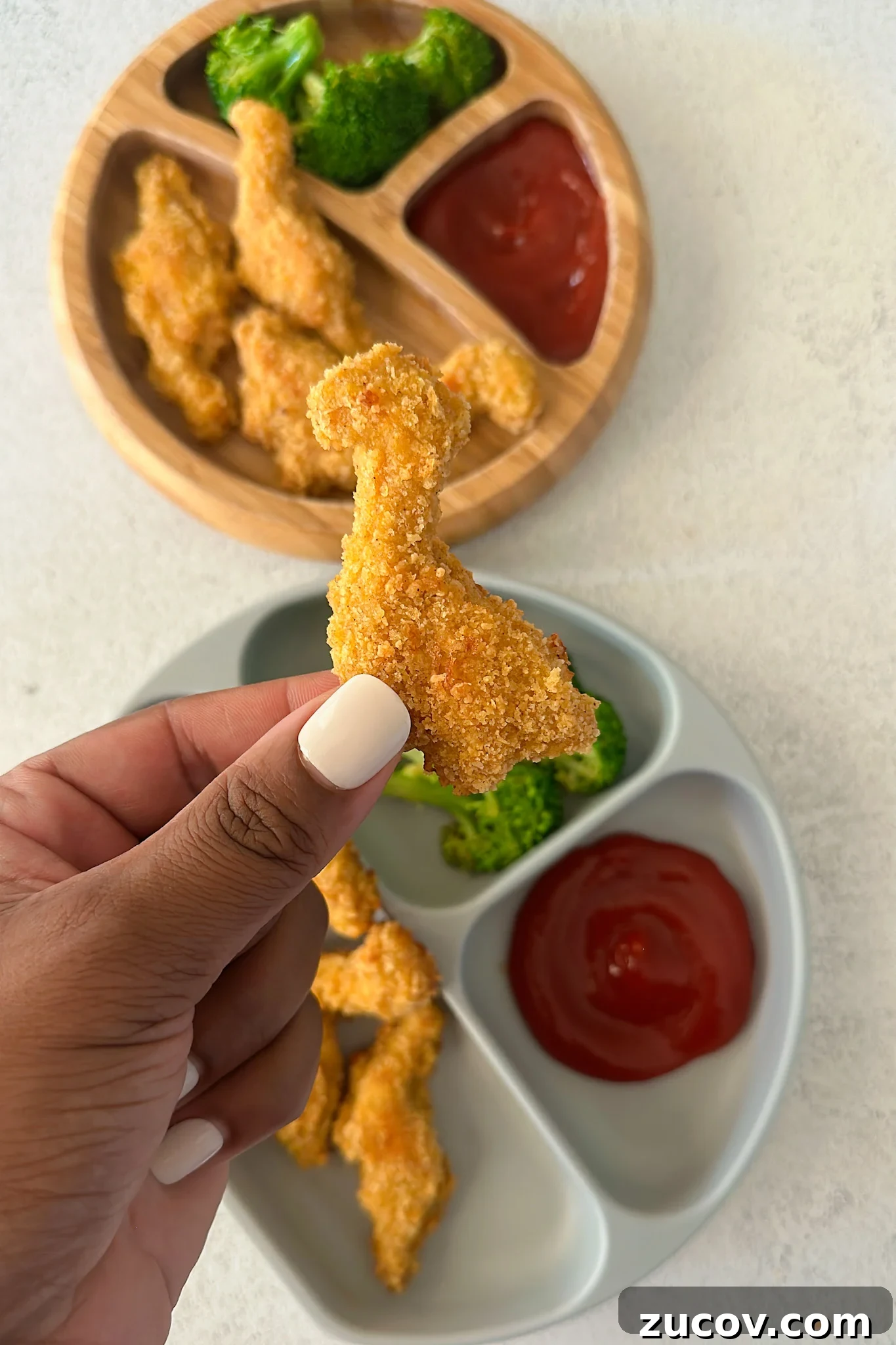 Dino nuggets served with broccoli and ketchup.
