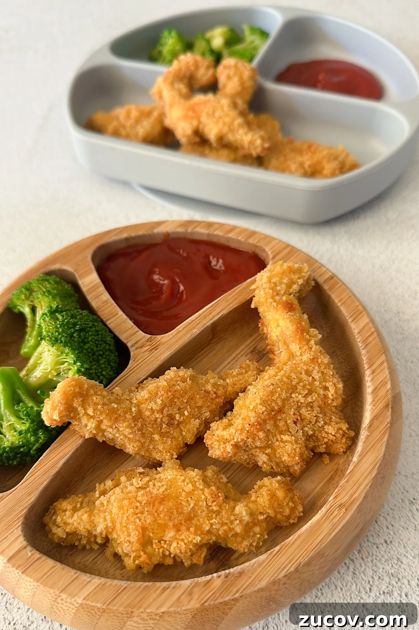 Dino nuggets served with broccoli and ketchup.