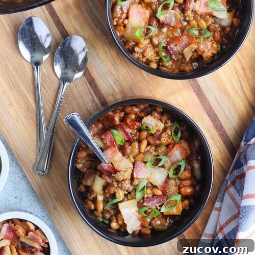 Individual bowls of baked beans garnished with chopped bacon and sliced green onions.