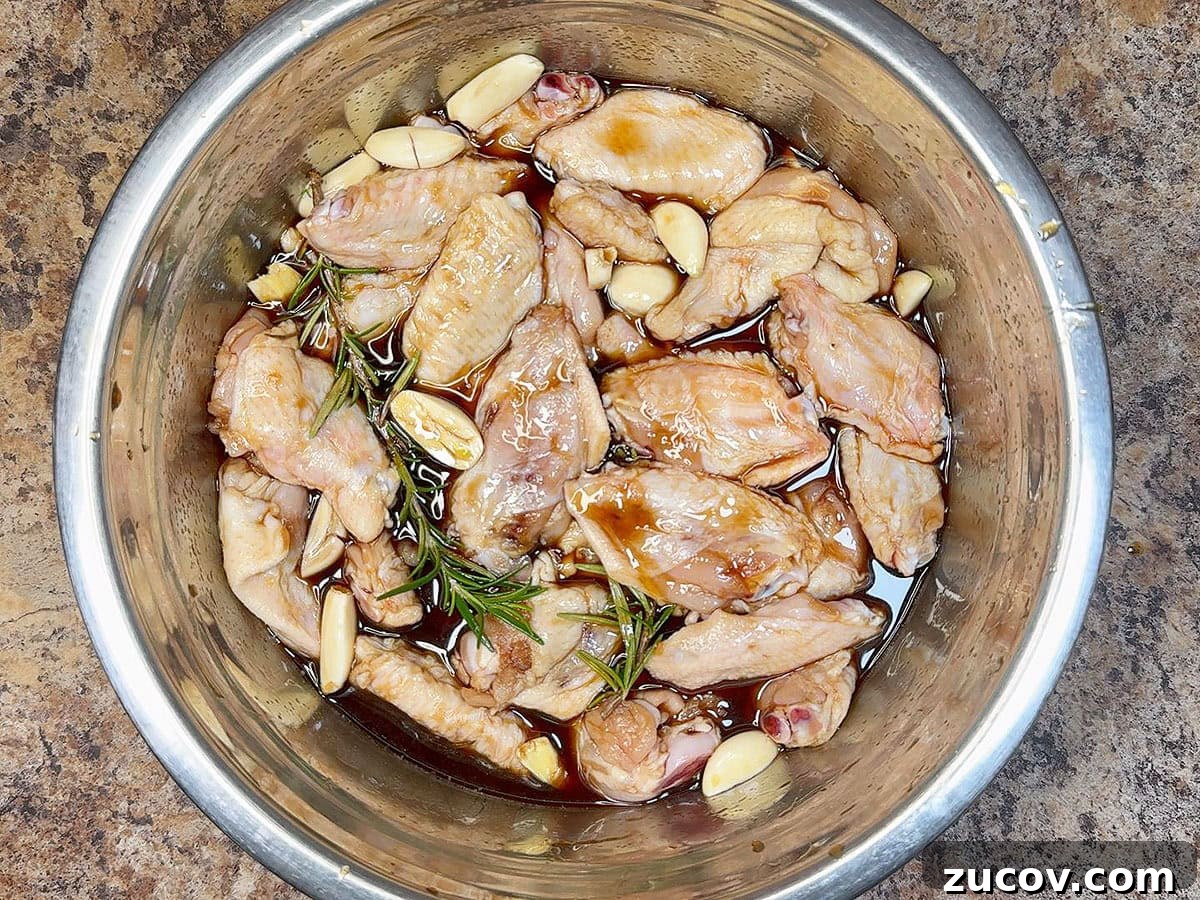 Sticky Honey Garlic Chicken Wings Recipe for Crispy Oven-Baked Wings 5 Chicken wings marinating in a large mixing bowl.