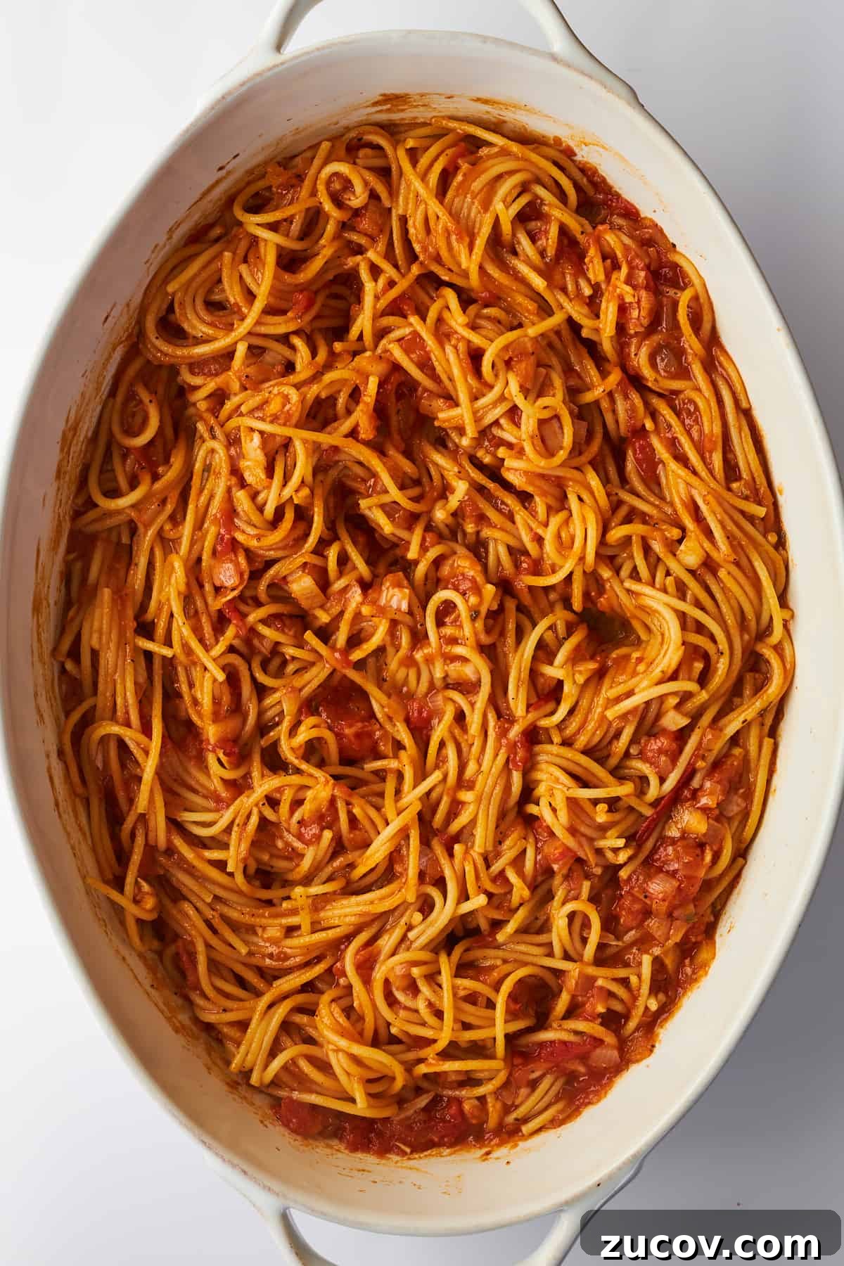 Cheesy Oven-Baked Spaghetti Casserole Recipe 8 An oval baking dish full of baked spaghetti.
