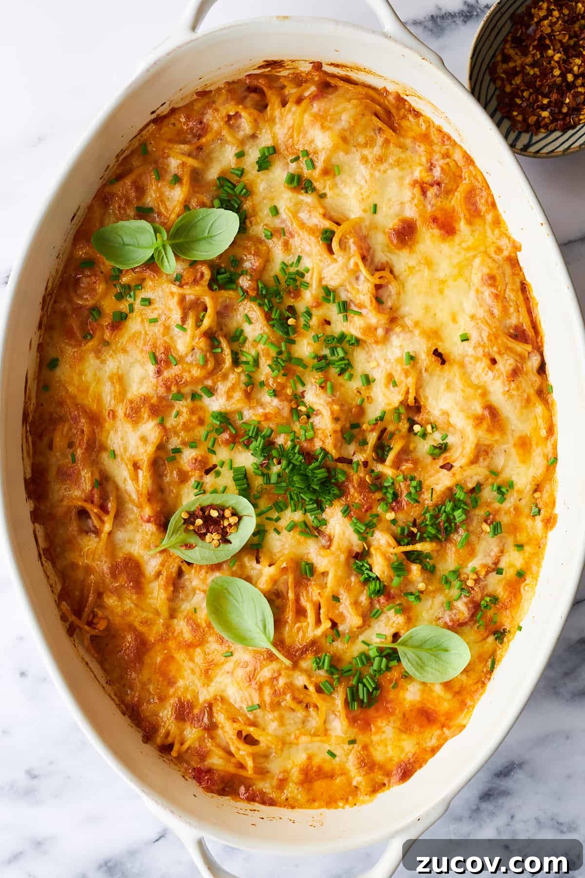 Cheesy Oven-Baked Spaghetti Casserole Recipe 10 Cheesy baked spaghetti in an oval baking dish.