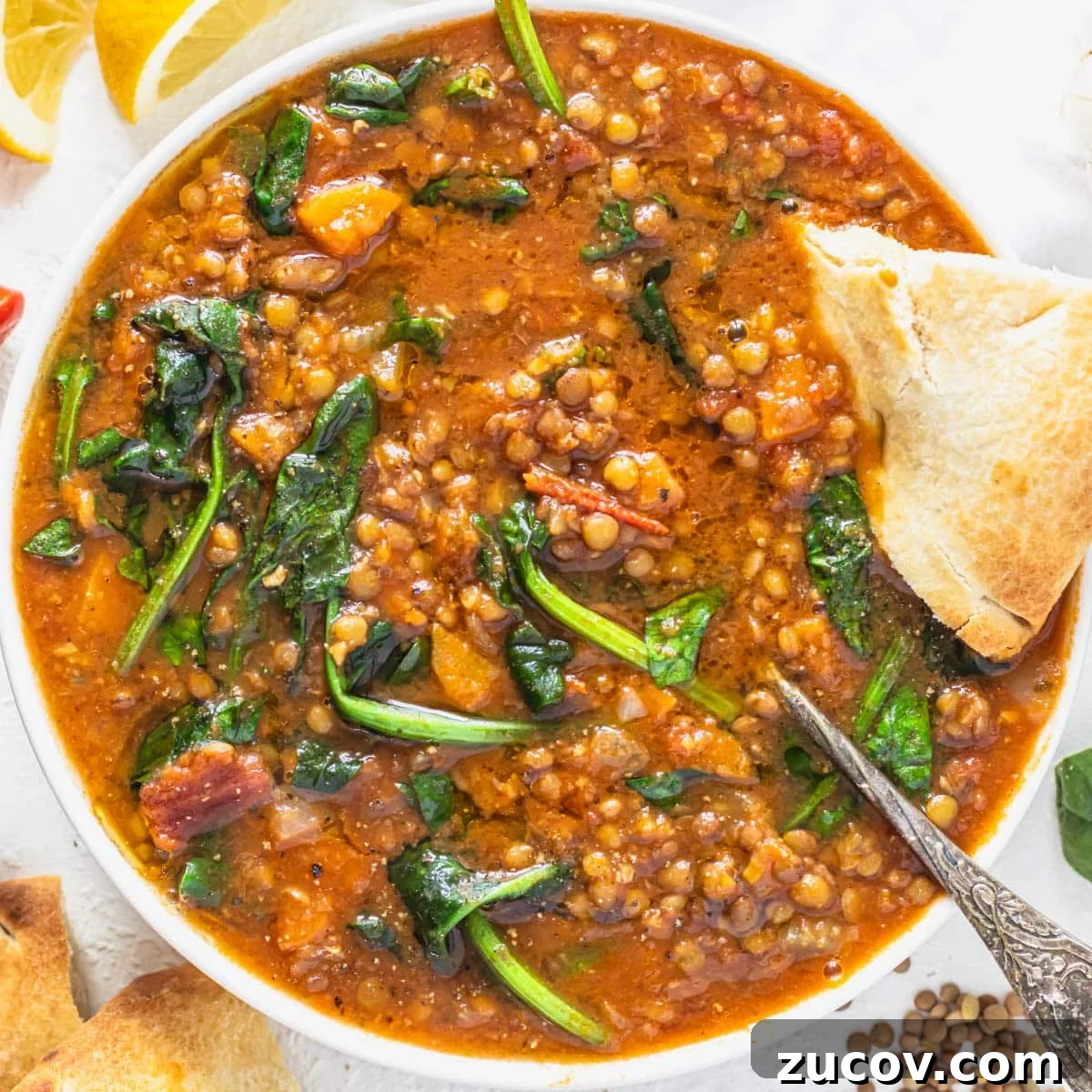 25 Affordable Recipes That Taste Gourmet on a Budget 11 Lentil vegetable soup with spinach, a silver spoon and bread