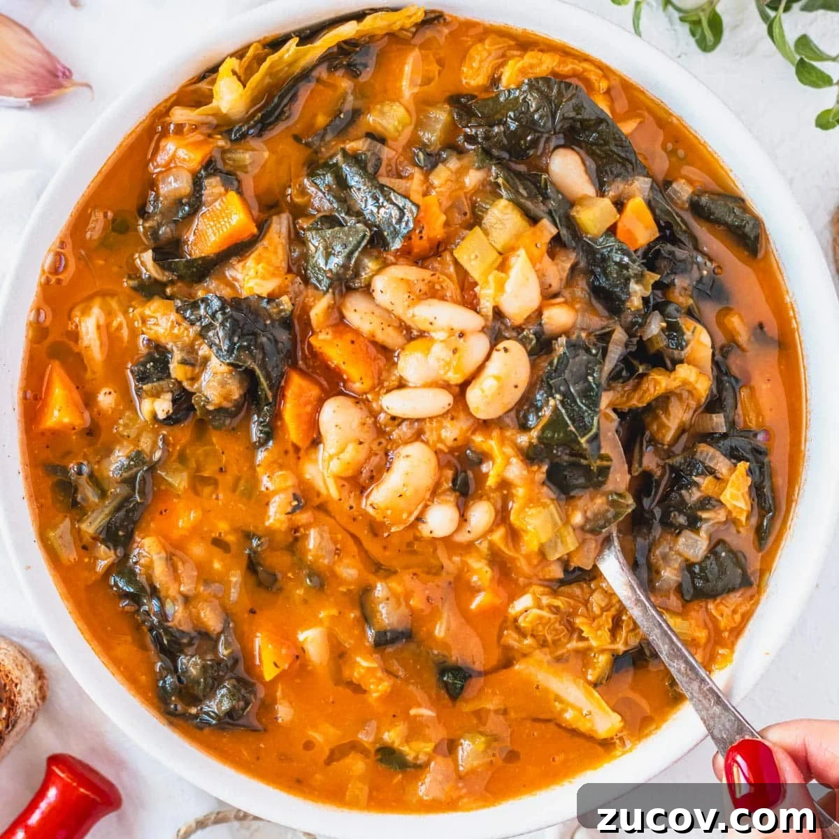 25 Affordable Recipes That Taste Gourmet on a Budget 8 Tuscan white bean soup with hand and red nails