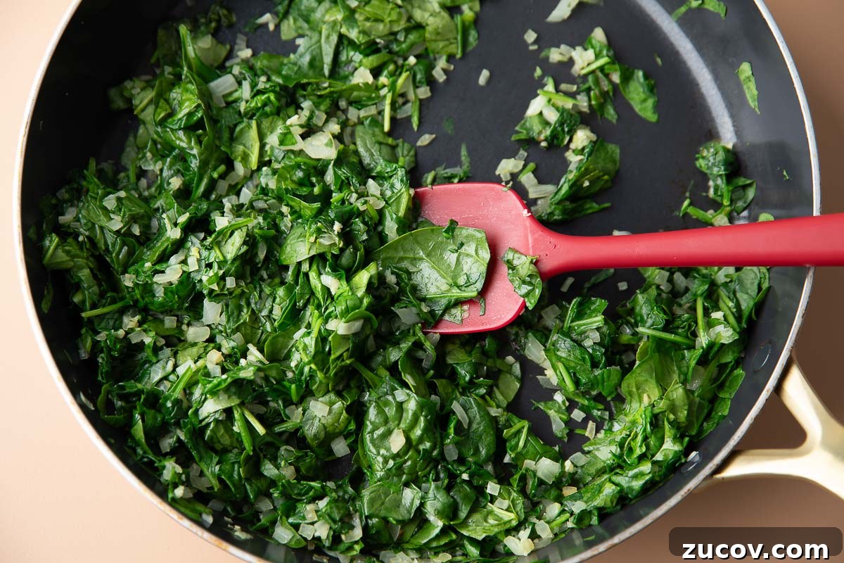 Silky Creamed Spinach Recipe: Quick Side Dish for Any Meal 4 baby spinach sauteed in a skillet with minced garlic and onion