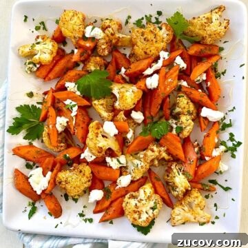 Roasted carrots and cauliflower with goat cheese on a plate.