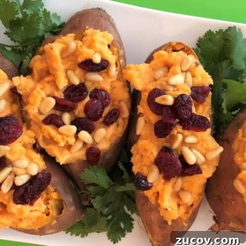 platter of coconut stuffed sweet potatoes topped with dried cranberries and pine nuts