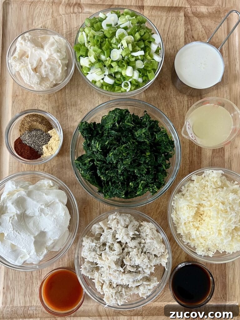 Creamy Baked Crab and Spinach Dip for Parties and Game Day 4 All recipe ingredients in glass bowls on cutting board.