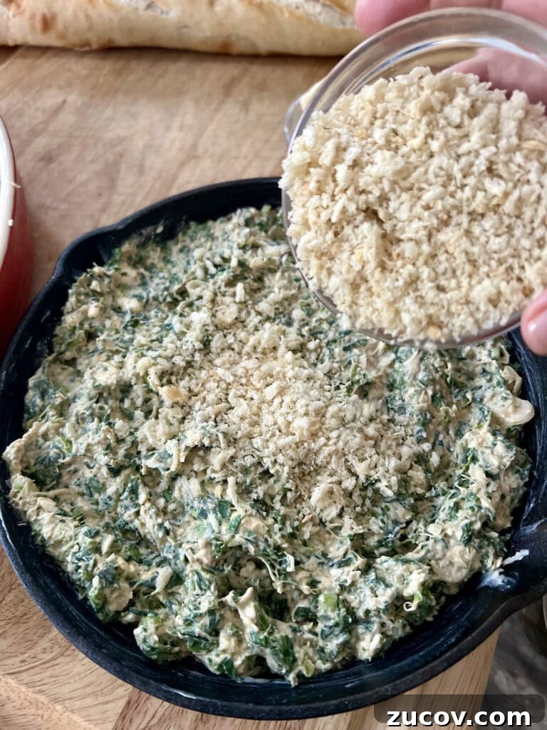 Creamy Baked Crab and Spinach Dip for Parties and Game Day 9 Sprinkling the prepared dip mixture in cast iron pan with panko breadcrumbs.