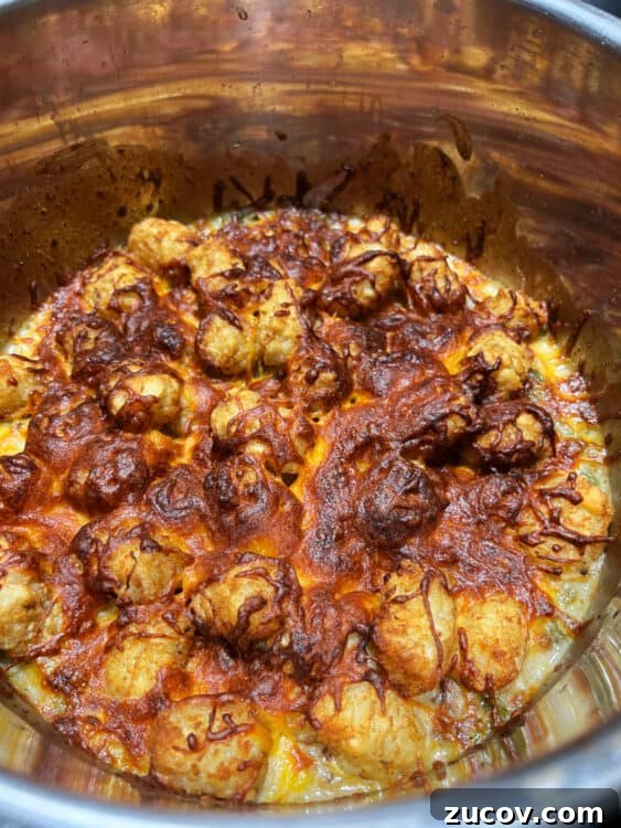 Cheesy Tater Tot Casserole Made in the Instant Pot 6 cooked tater tots and cheese on top of the casserole in the instant pot