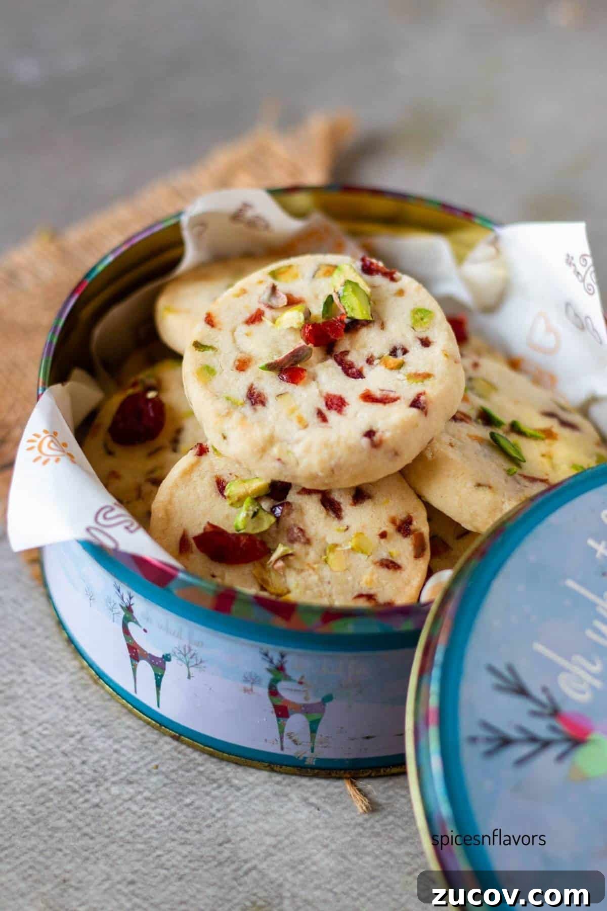 Cranberry Pistachio Shortbread Cookies (Egg-Free) 2 Cranberry Pistachio shortbread cookies placed in a cookie tin