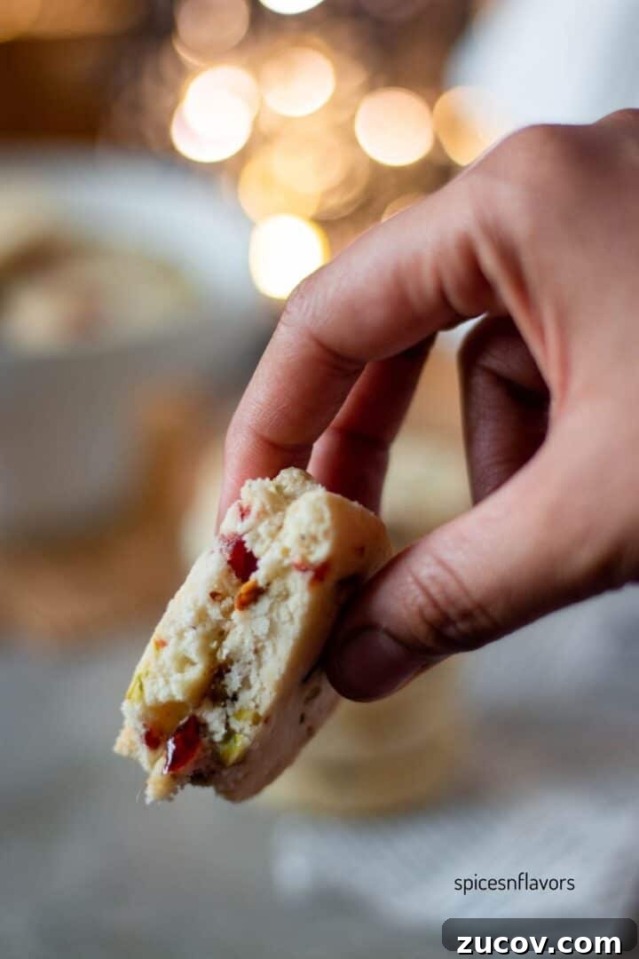 Cranberry Pistachio Shortbread Cookies (Egg-Free) 10 sliced cranberry pistachio shortbread cookies held in your fingers