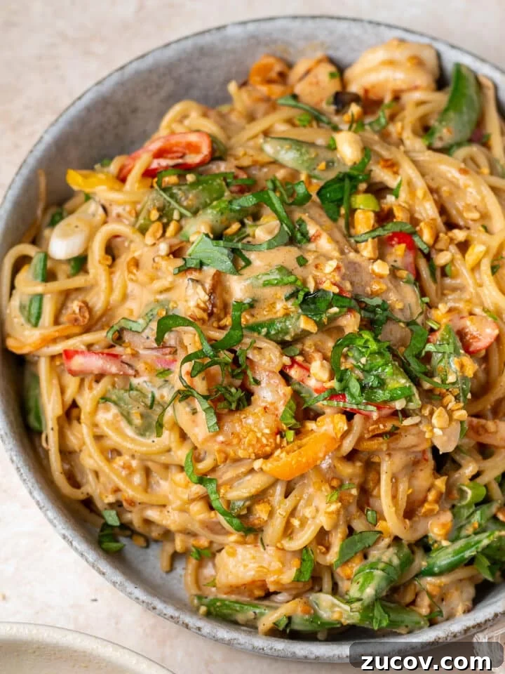 Large bowl of thai peanut noodles with shrimp, spaghetti noodles, and creamy peanut sauce