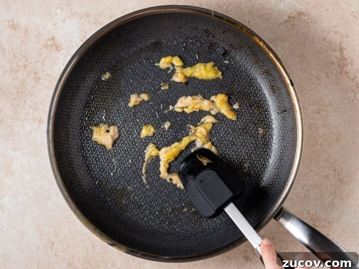 Garlic and ginger sautéing in a skillet for shrimp peanut sauce 