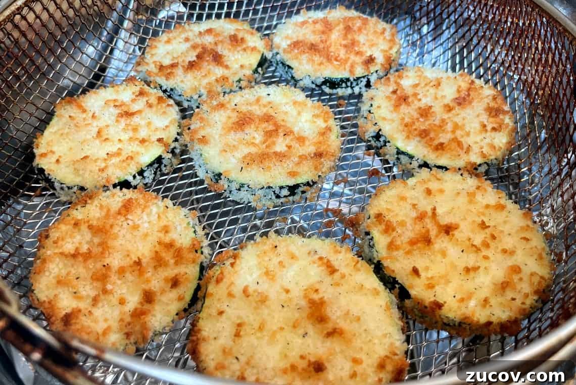 Crispy Air Fryer Zucchini Chips Recipe 9 fried zucchini in an air fryer basket.