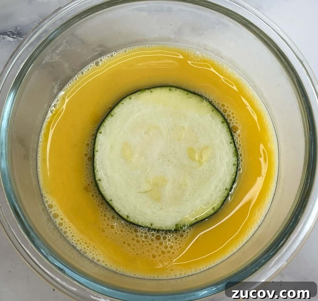 Crispy Air Fryer Zucchini Chips Recipe 5 zucchini in egg dip.