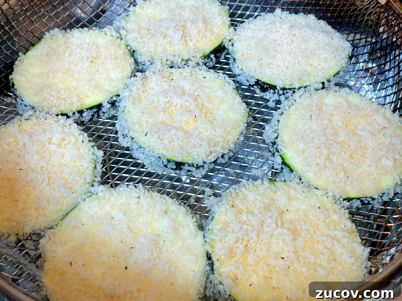 Crispy Air Fryer Zucchini Chips Recipe 8 zucchini slices in an air fryer before frying.