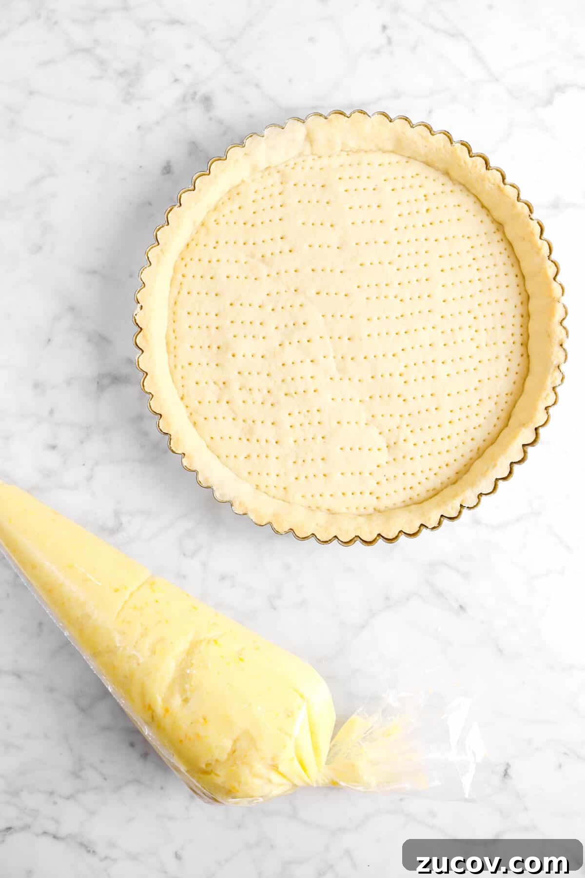 baked tart shell with custard in piping bag
