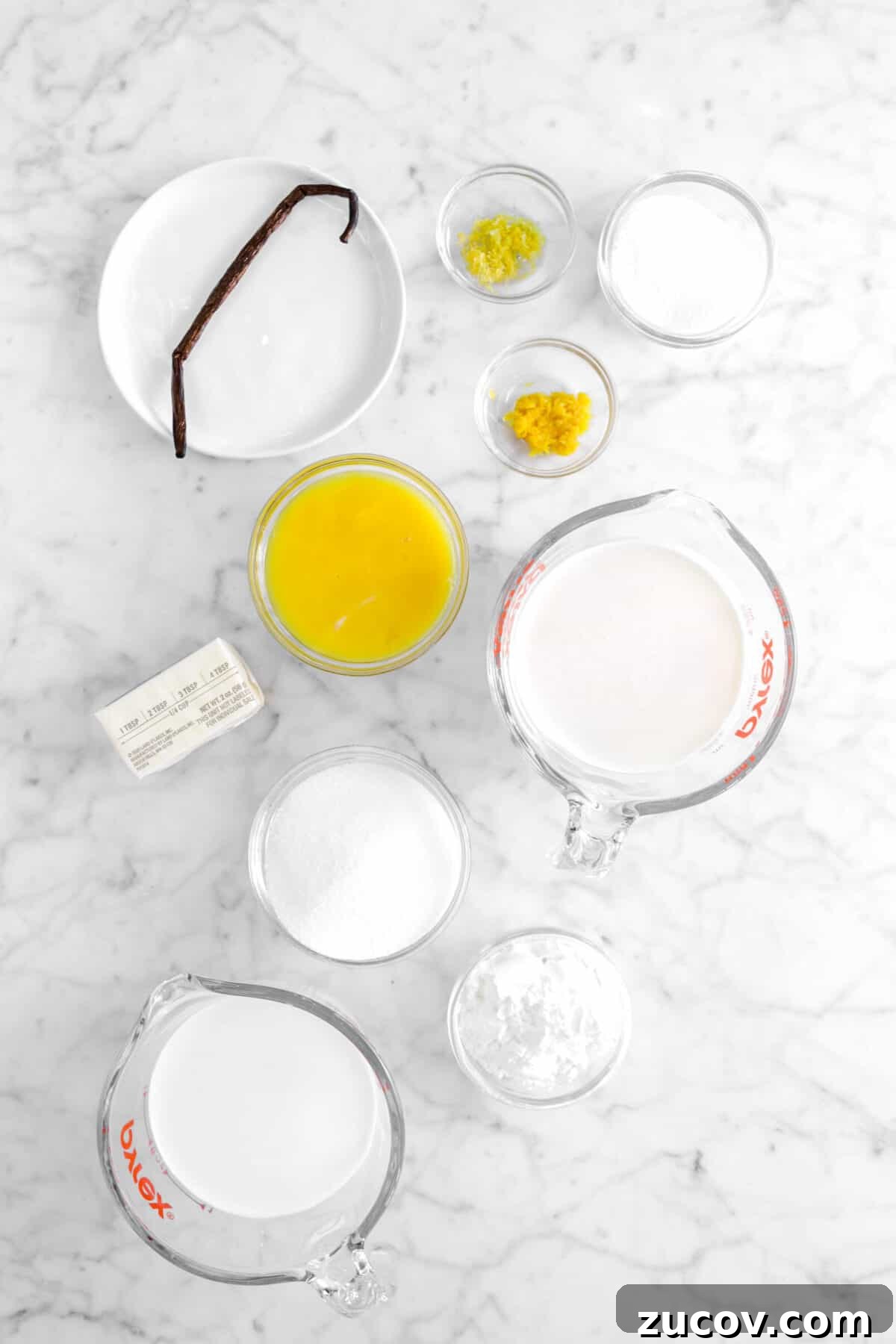vanilla bean, orange zest, grapfruit zest, sugar, egg yolks, milk butter, corn start, and cream on marble counter