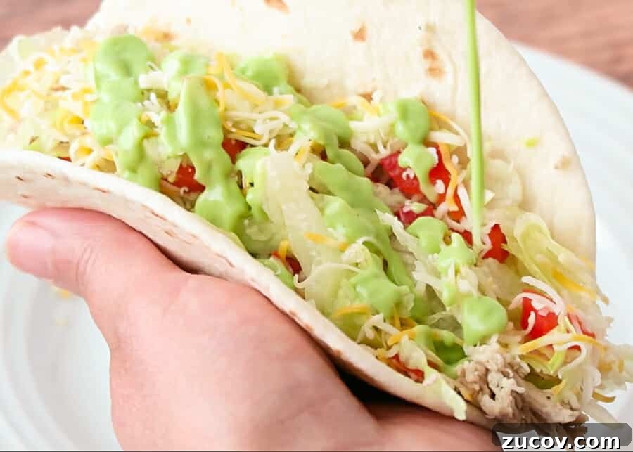 Creamy Avocado Yogurt Sauce with Greek Yogurt 11 creamy avocado sauce being drizzled on a taco