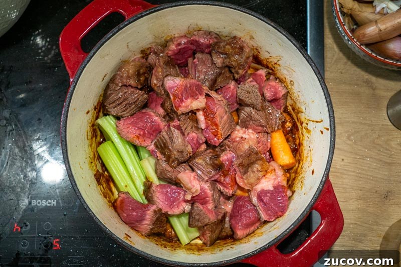 Classic Old-Fashioned Beef Stew Recipe (No Wine) 8 Adding beef chunks, carrots and celery to the pot