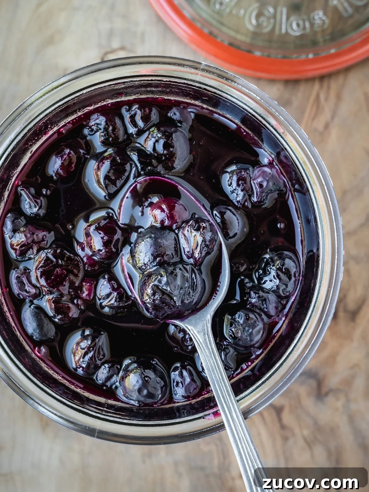Maple Blueberry Compote Recipe for Pancakes and Yogurt 7 Blueberry Maple Compote in a jar with a spoon.