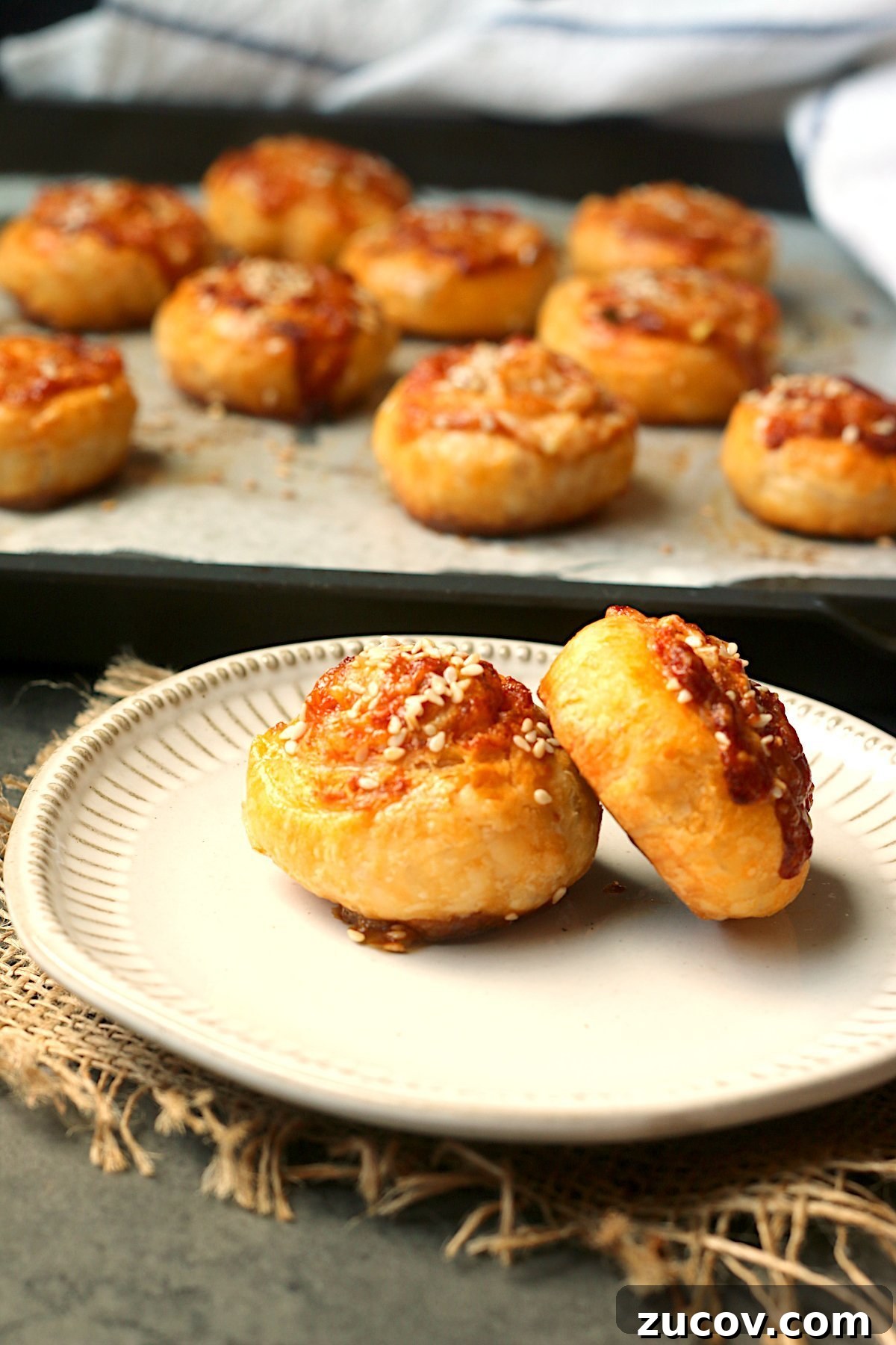 Gochujang Cheddar Pinwheel Appetizers: Spicy Korean Cheese Rolls 6 Two gochujang cheddar pinwheels on a plate.