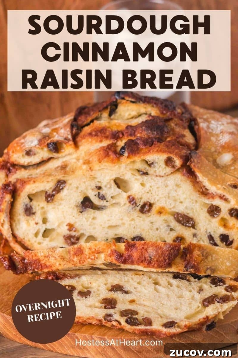 Sourdough Cinnamon Raisin Bread Recipe — Soft, Sweet & Spiced 19 An image for Pinterest of a golden brown sourdough cinnamon raisin bread with visible raisins and cinnamon swirls, cooling on a cutting board. Hostess At Heart