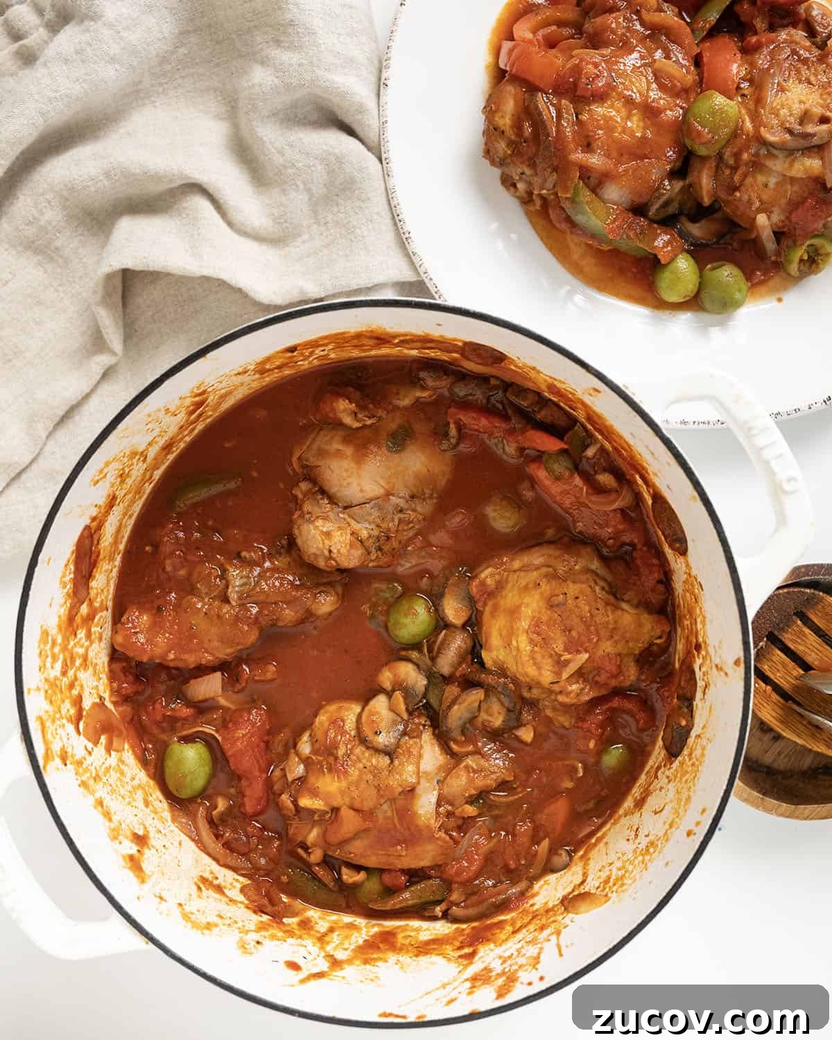 Classic Chicken Cacciatore Recipe: Rustic Italian Chicken Stew 9 Finished chicken cacciatore on a plate and the remaining in a dutch oven.
