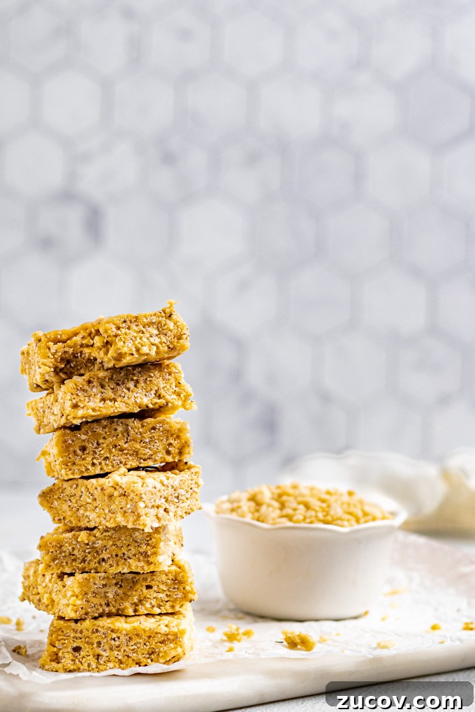 Rice Krispie Treats Without Marshmallows – Chewy Almond Butter Bars 6 A stack of healthy rice krispie treats are on the left corner. A bowl of rice cereal is off to the side.