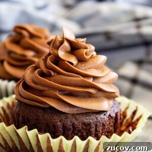 Decadent Chocolate Cream Cheese Frosting Recipe 6 Frosting piped in a swirl on top of a chocolate cupcake.
